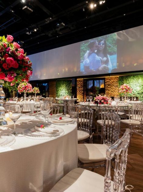 Elegant event space with round tables, floral centerpieces, crystal glassware, and soft lighting